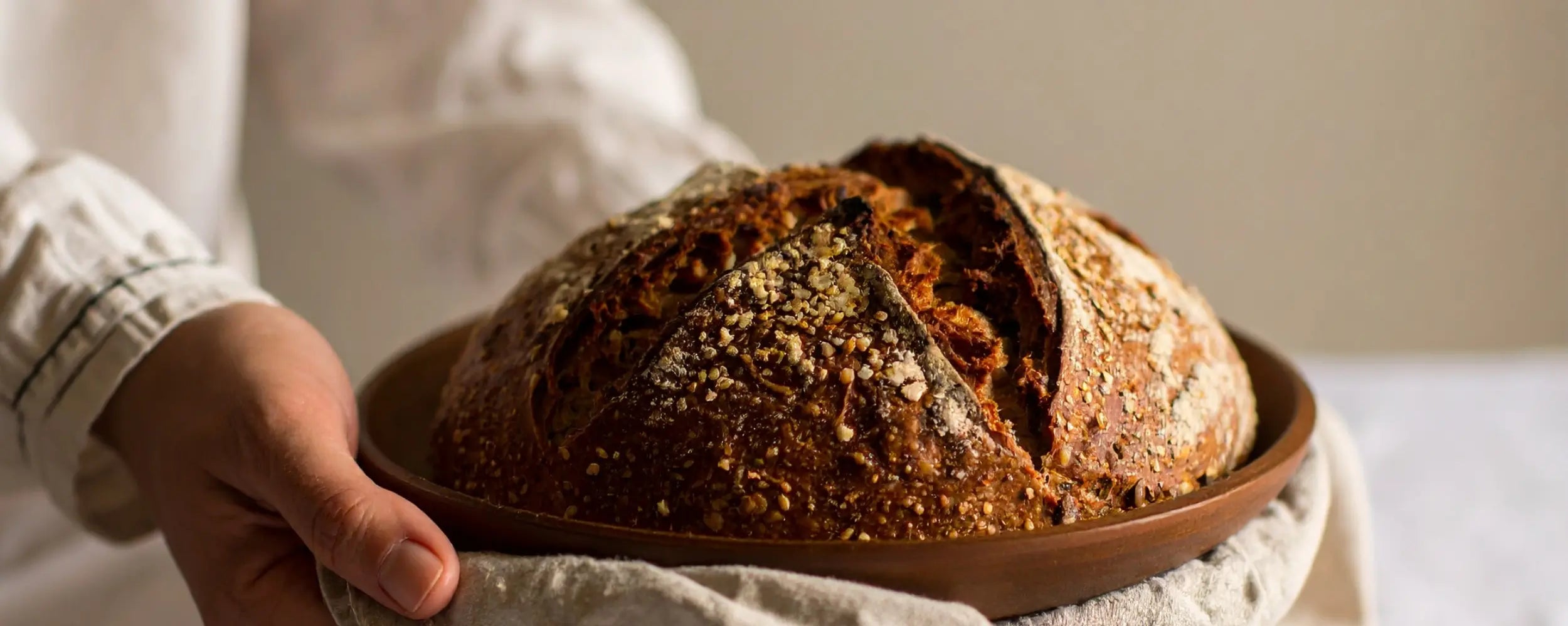 Freshly baked homemade sourdough bread loaf on rustic plate — Akia Collection